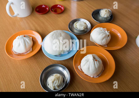 Quelques assiettes de petits pains cuits à la vapeur sur la table dans un restaurant dim sum local, Melaka, Malaisie. Banque D'Images