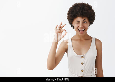 Je l'ai eu, tout est excellent. Portrait de heureux et confiant emotive femme avec la peau foncée et de l'afro hairstyle clignant de l'indice et avec Banque D'Images