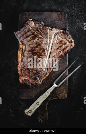 Grillades de Bœuf Barbecue sèche T-bone steak sur Brown Vintage à découper Banque D'Images