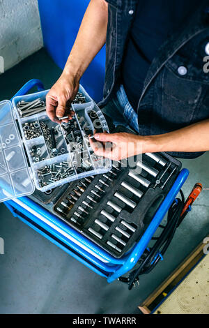 Les mains du mécanicien le choix de vis une boîte à outils Banque D'Images