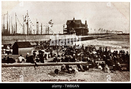 Les vacanciers sur la plage, avec l'embarcadère à l'arrière-plan, Lowestoft, Suffolk. Date : vers 1910