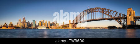 Sydney Harbour Bridge et Opera House Panorama avec ciel bleu et l'eau à la lumière du jour, Sydney Australie le lever du soleil, la nuit, pas de large. Banque D'Images