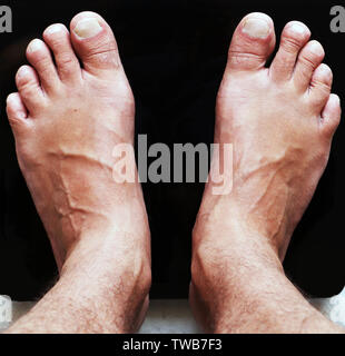 Pieds de marbre noir sur des échelles numériques en verre. Le régime alimentaire et le poids corporel. Vue du haut vers le bas. Sport et vie concept. Homme debout sur l'échelle. Banque D'Images