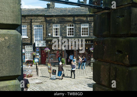 Les touristes profitant d'une journée d'été dans le village de Haworth dans le Yorkshire de l'UK, célèbre comme la maison des soeurs Bronte Banque D'Images