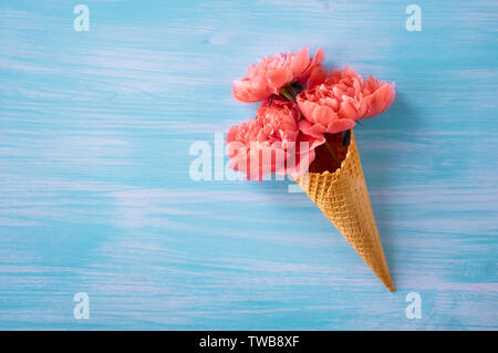Les Pivoines couleur corail. Un bouquet de pivoines dans un cône de crème glacée. Color 2019. Un design créatif. le minimalisme. Banque D'Images