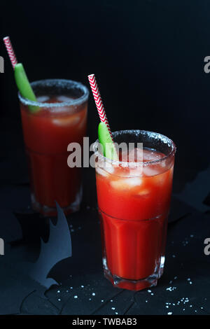 Cocktail Bloody Mary ou la Vierge Marie avec un concombre sur un fond sombre avec des chauves-souris. Halloween concept, selective focus. Banque D'Images