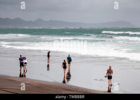 Un groupe de personnes à pied le long de Hot Water Beach (Plage), de l'océan, île du Nord Kawhia, Nouvelle-Zélande Banque D'Images