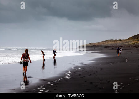 Un groupe de personnes à pied le long de Hot Water Beach (Plage), de l'océan, île du Nord Kawhia, Nouvelle-Zélande Banque D'Images