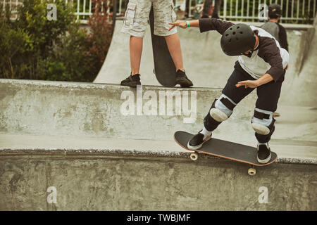 Jeune garçon jouant la raie et faisant des tours dans le skate park à Milan Banque D'Images