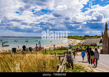 Les gens se dirigent vers la plage un jour d'été ensoleillé à basse Newton-by-the-Sea, Northumberland, Angleterre. Août 2018. Banque D'Images