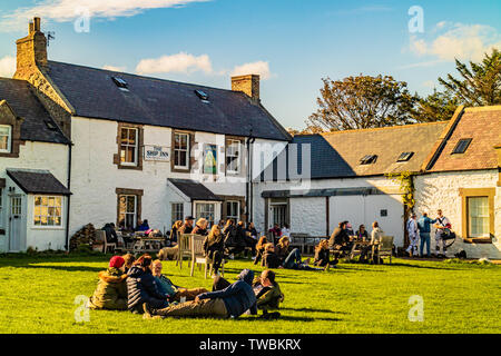 Les gens assis dans le carré à l'extérieur de la célèbre pub the Ship Inn en basse Newton-by-the-Sea, Northumberland, Angleterre. Septembre 2018. Banque D'Images