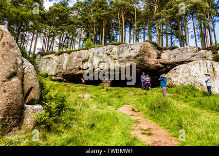 Les promeneurs et les vacanciers appréciant la grotte de St Cuthbert, un affleurement de grès dans le Northumberland, au Royaume-Uni. Juin 2019. Banque D'Images