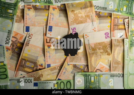 Un papier noir tirelire avec des billets en euros en arrière-plan Banque D'Images