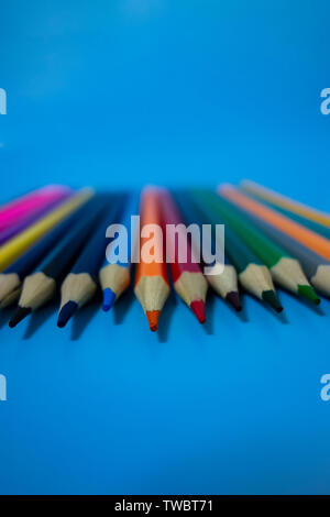 Un crayon de couleur sont soigneusement disposées dans un fond bleu Banque D'Images