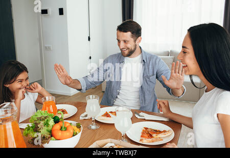 Famille, mère, père et fille durant le dîner.manger des pizzas à la maison Banque D'Images