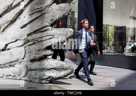 Les hommes d'affaires de la ville à pied au-delà de la sculpture intitulée 'ville' aile sur Threadneedle Street dans la ville de Londres, le quartier financier de la capitale, le 17 juin 2019, à Londres, en Angleterre. Cette dix mètres de haut est la sculpture en bronze par le président de la Royal Academy of Arts, Christopher Le Brun, commandé par Hammerson en 2009. 'La Ville' de l'aile et a été jeté par Morris Singer, fondateurs de l'art réputé pour être la plus ancienne fonderie d'art dans le monde. Banque D'Images