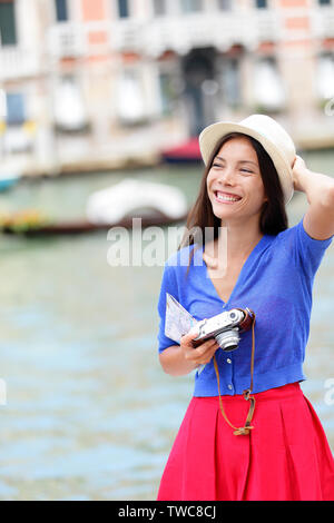 Billet touriste voyageant à Venise, Italie tenir l'appareil photo et de la carte. Asian girl en vacances smiling happy par Grand Canal. Young Asian Woman s'amusant pendant les vacances en Europe. Banque D'Images