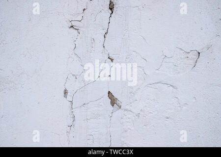 Vieux mur de plâtre blanc avec des traces de longues fissures Banque D'Images