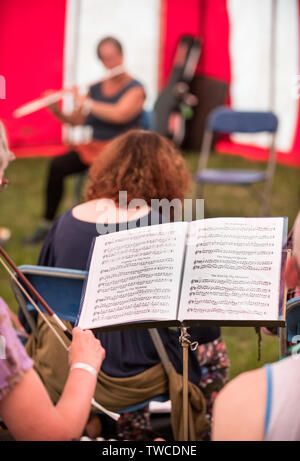 Des ateliers de musique dans un grand chapiteau rayé à la folk music festival. Banque D'Images