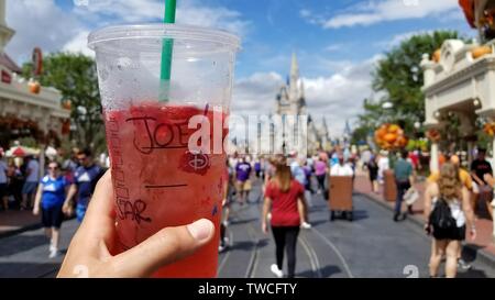 Tenant une tasse de Starbucks dans Walt Disney World avec le château en arrière-plan et à la recherche sur la rue principale. Banque D'Images