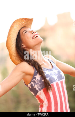 American cowgirl femme libre et heureux wearing cowboy hat à l'extérieur dans la campagne. Cheerful joie femme joyeuse smiling jouissant de la liberté. Belle mixed race Woman modèle féminin asiatique. Banque D'Images