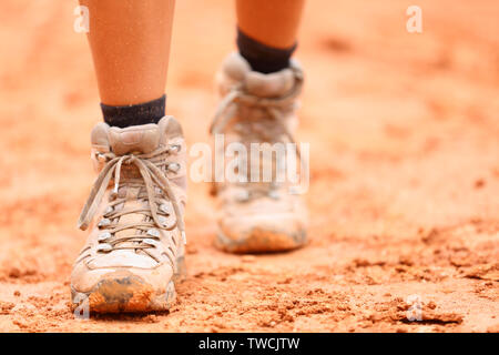 Des chaussures de randonnée - gros plan du randonneur sales bottes. Femme pieds et chaussures de randonnée femme walking on dirt trail randonnée pédestre sentier de nature en plein air. Banque D'Images