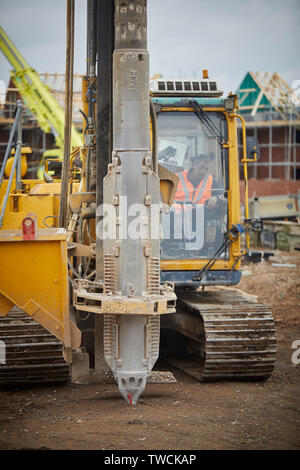 Pile Driver rig au travail sur un chantier de construction pour les nouvelles maisons en pierre dans le forçage de Cheshire fondations Banque D'Images