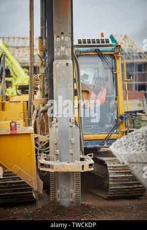 Pile Driver rig au travail sur un chantier de construction pour les nouvelles maisons en pierre dans le forçage de Cheshire fondations Banque D'Images