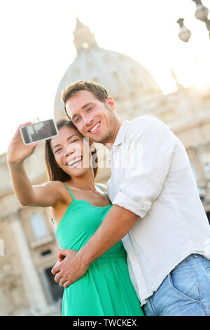 Couple de touristes par selfies du Vatican et de la basilique de Rome. Happy travel la femme et l'homme de prendre photo sur photo selfies lune de miel romantique en Italie. Banque D'Images