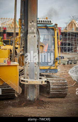 Pile Driver rig au travail sur un chantier de construction pour les nouvelles maisons en pierre dans le forçage de Cheshire fondations Banque D'Images