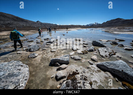 Les randonneurs de traverser une étendue d'eau en route pour Chukarpo Wangdue Phodrang, district, le Snowman Trek, Bhoutan Banque D'Images