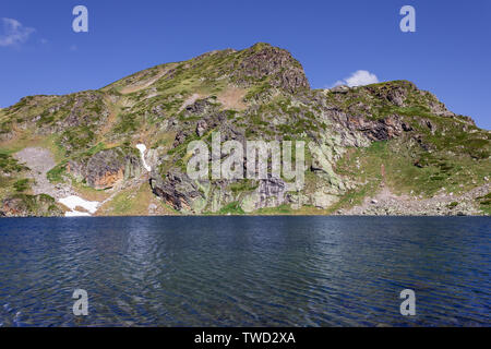 Voir d'amazing, Rocky, colorée et une montagne ensoleillée pic sur la montagne de Rila en Bulgarie plus de rein d'un bleu profond d'un lac sur une randonnée de sept lacs de Rila Banque D'Images