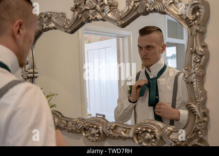 Le marié se prépare pour son mariage en face du miroir, Jennycliff, Plymouth, Devon, UK Banque D'Images