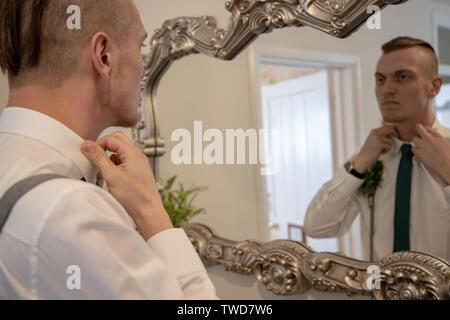 Le marié se prépare pour son mariage en face du miroir, Jennycliff, Plymouth, Devon, UK Banque D'Images