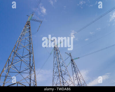 Trois tours de lignes à haute tension de l'énergie en milieu urbain. Banque D'Images