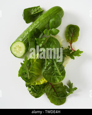 Vue aérienne sur les légumes verts et le concombre unique avec des extrémités coupé sur fond blanc Banque D'Images