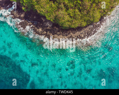 Mer baie aux eaux turquoises et d'une petite plage de sable blanc. Magnifique lagon et l'île volcanique couverte de forêts denses, vue d'en haut Banque D'Images