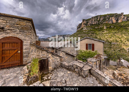 Scène de rue pavée du village avec des maisons à toits de tuiles d'ardoise dans le Rozier dans les Gorges du Tarn, Cévennes, France Banque D'Images