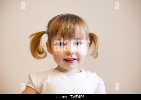 Cute smiling enfant fille avec deux couettes et quiff closeup portrait Banque D'Images