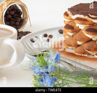 Tiramisu maison ronde, sans cuisson dessert sucré traditionnel italien. Tableau bleu avec du gâteau, bol avec la poudre de cacao, biscuits éponge ronde, les grains de café Banque D'Images