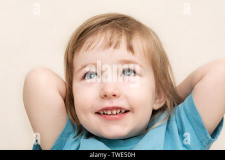 Drôle de fille rêveuse enfant blanc émotionnelle face closeup sur rond wall background Banque D'Images