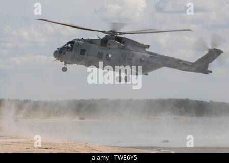 190615-M-QF372-1218 Lituanie (15 juin 2019) - Un hélicoptère Merlin plane comme Royal Marines britanniques se préparent à descendre en rappel sur la plage pour un assaut amphibie de l'exercice Baltic Operations (exercice BALTOPS) 2019 Journée des visiteurs de marque à Palanga, Lituanie, 15 juin 2019. Les membres en service de plusieurs pays de l'OTAN ont démontré leurs capacités amphibies et de coopération dans un assaut amphibie en Lituanie pour l'exercice. Est un rapport annuel conjoint BALTOPS, force maritime multinationale-exercice ciblé. Il est conçu pour améliorer la formation des participants, de favoriser la flexibilité et interorganisations Banque D'Images