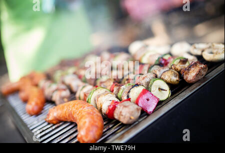 Un assortiment de viande de poulet, porc et légumes divers sur la grille du barbecue Banque D'Images