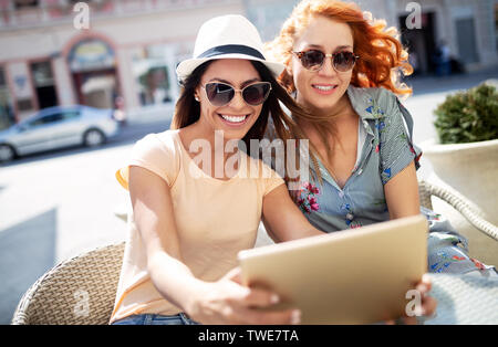 Belles filles s'amusant smiling together in a cafe outdoor Banque D'Images