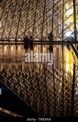 Paris, France, Octobre 04, 2018 : le palais du Louvre et la pyramide (par nuit) comme entrée à l'intérieur du Louvre, les touristes à visiter, prendre des photos Banque D'Images