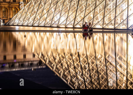 Paris, France, Octobre 04, 2018 : le palais du Louvre et la pyramide (par nuit) comme entrée à l'intérieur du Louvre, les touristes à visiter, prendre des photos Banque D'Images