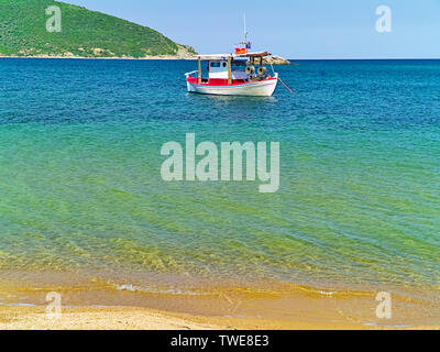 Belle plage de sable avec une eau cristalline et voile à Nea Peramos, Grèce. Banque D'Images