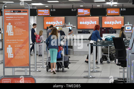 20 juin 2019, le Brandebourg, Schönefeld : vacanciers sont debout au comptoir d'enregistrement à l'aéroport de Berlin-Schönefeld avec l'inscription easyjet. L'augmentation du nombre de passagers est prévu avec le début de la saison de vacances. Photo : Bernd Settnik/dpa-Zentralbild/dpa Banque D'Images