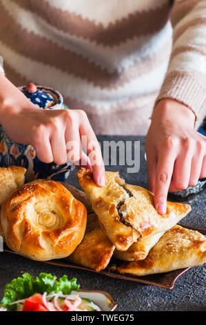 De l'est fraîchement cuits sur un plateau vintage samsa Close up.pâtisserie orientale traditionnelle - samsa rempli de viande. Banque D'Images