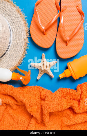 Été plage télévision jeter accessoires. Bouteille d'écran solaire crème, chapeau de paille, tongs, serviette et coquilles sur fond de couleur. Concept de vacances voyage wi Banque D'Images